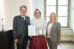 Die Schriftstellerin Claudia Rossbacher (M.) mit Landeshauptmann Christopher Drexler (l.) und der Nationalratsabgeordneten Verena Nussbaum (r.) bei der Überreichung des Goldenen Ehrenzeichens des Landes Steiermark.